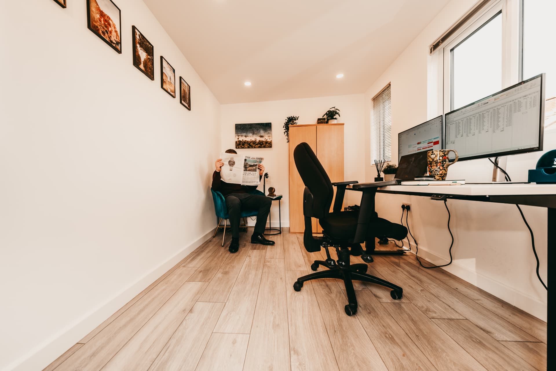 Garden office with a reading corner and a dual-monitor workstation by the window