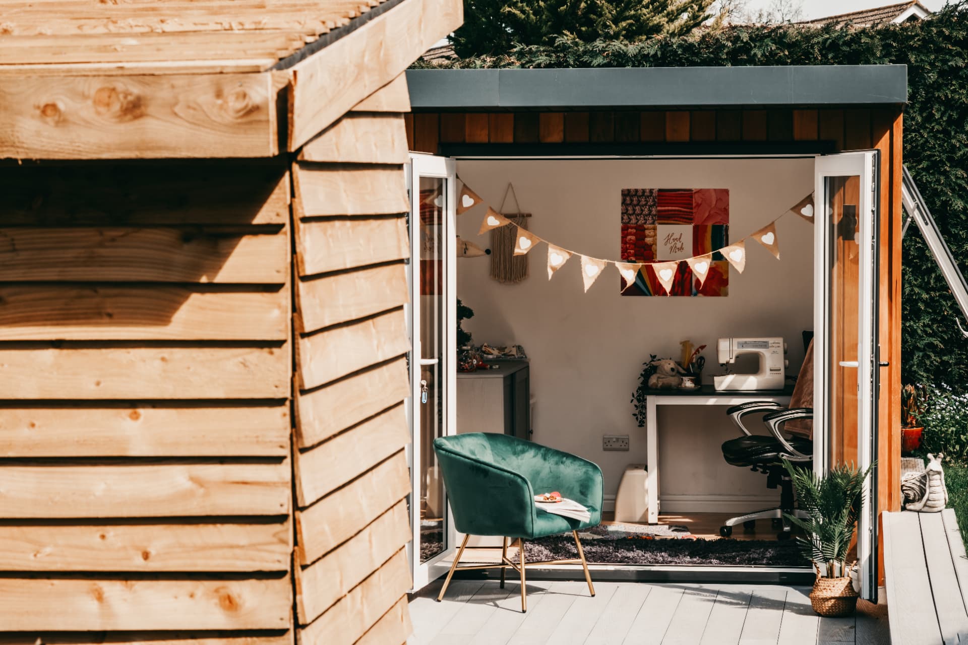 Cedar clad garden craft room with doors open in the afternoon sun