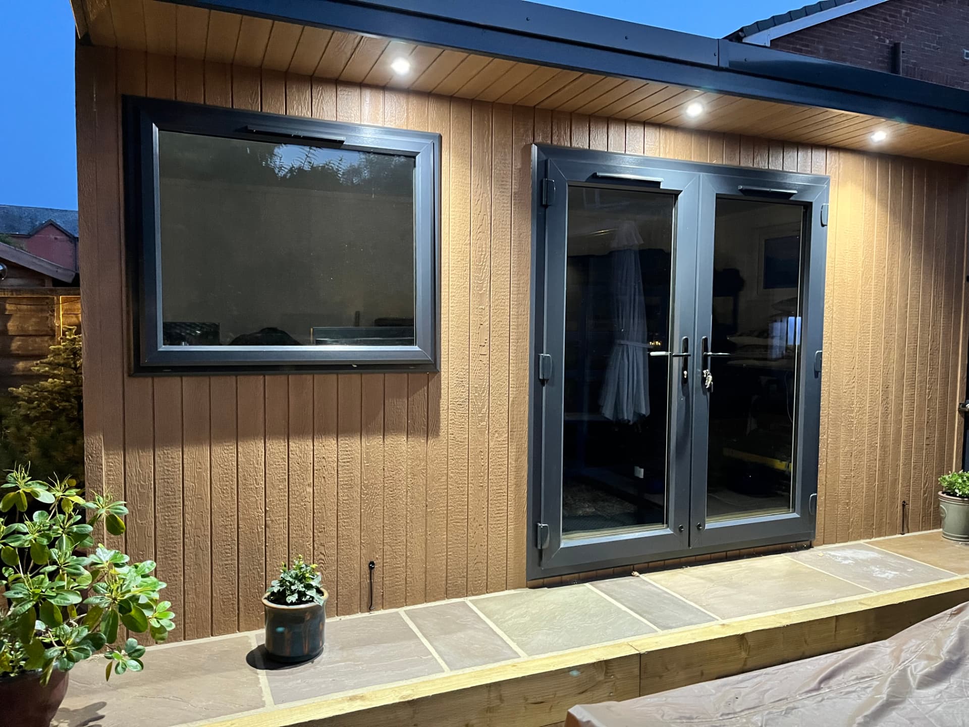 Cedar ToughWood garden room lit by soffit downlights at dusk