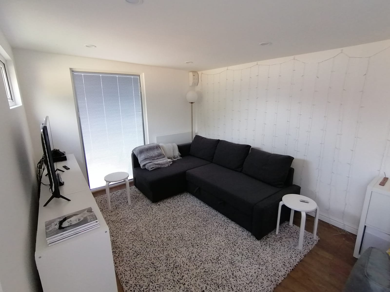 Garden room interior used as a snug with corner sofa, TV and full-height window
