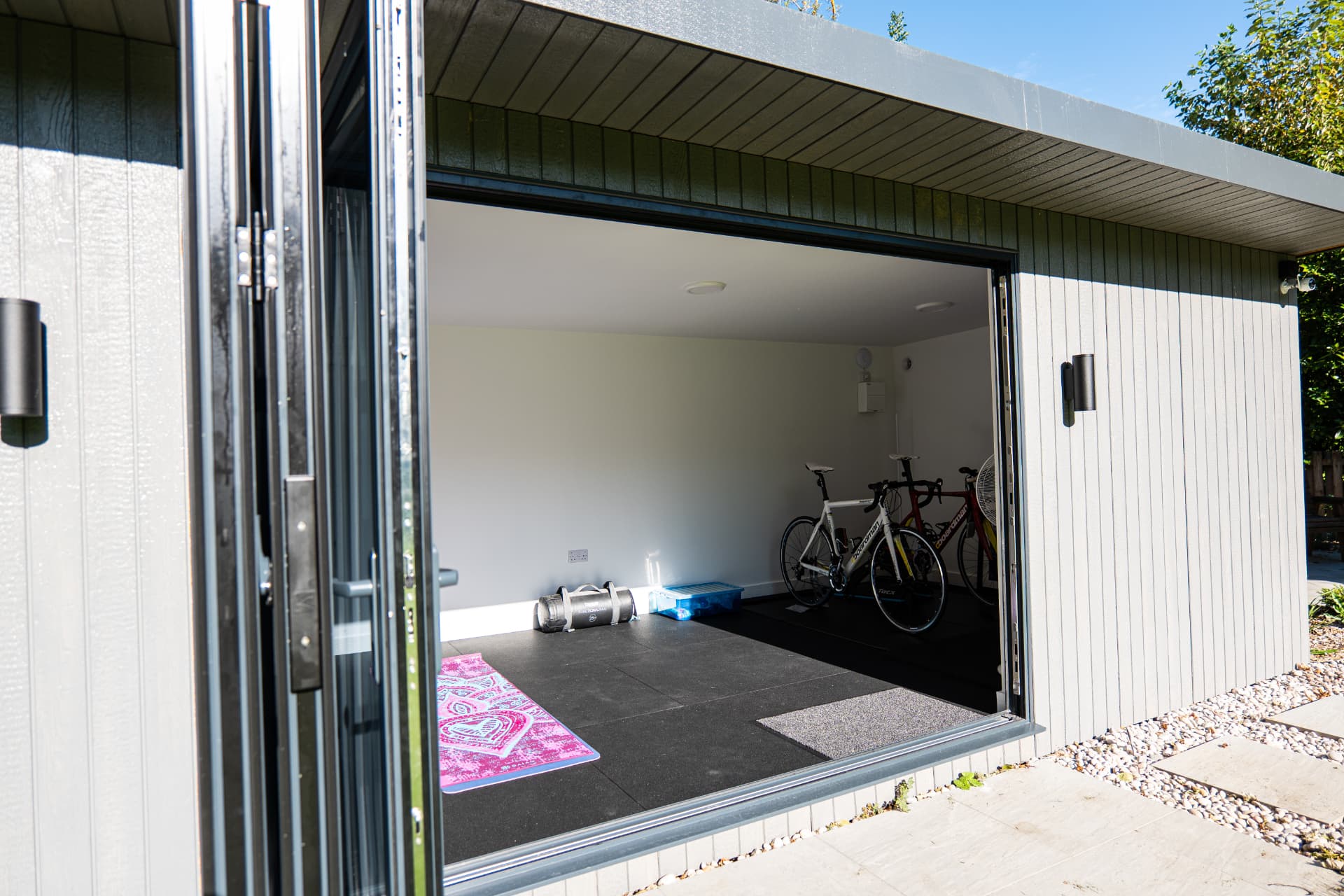 Mountain Ash garden room used as a home gym with bifold doors folded open
