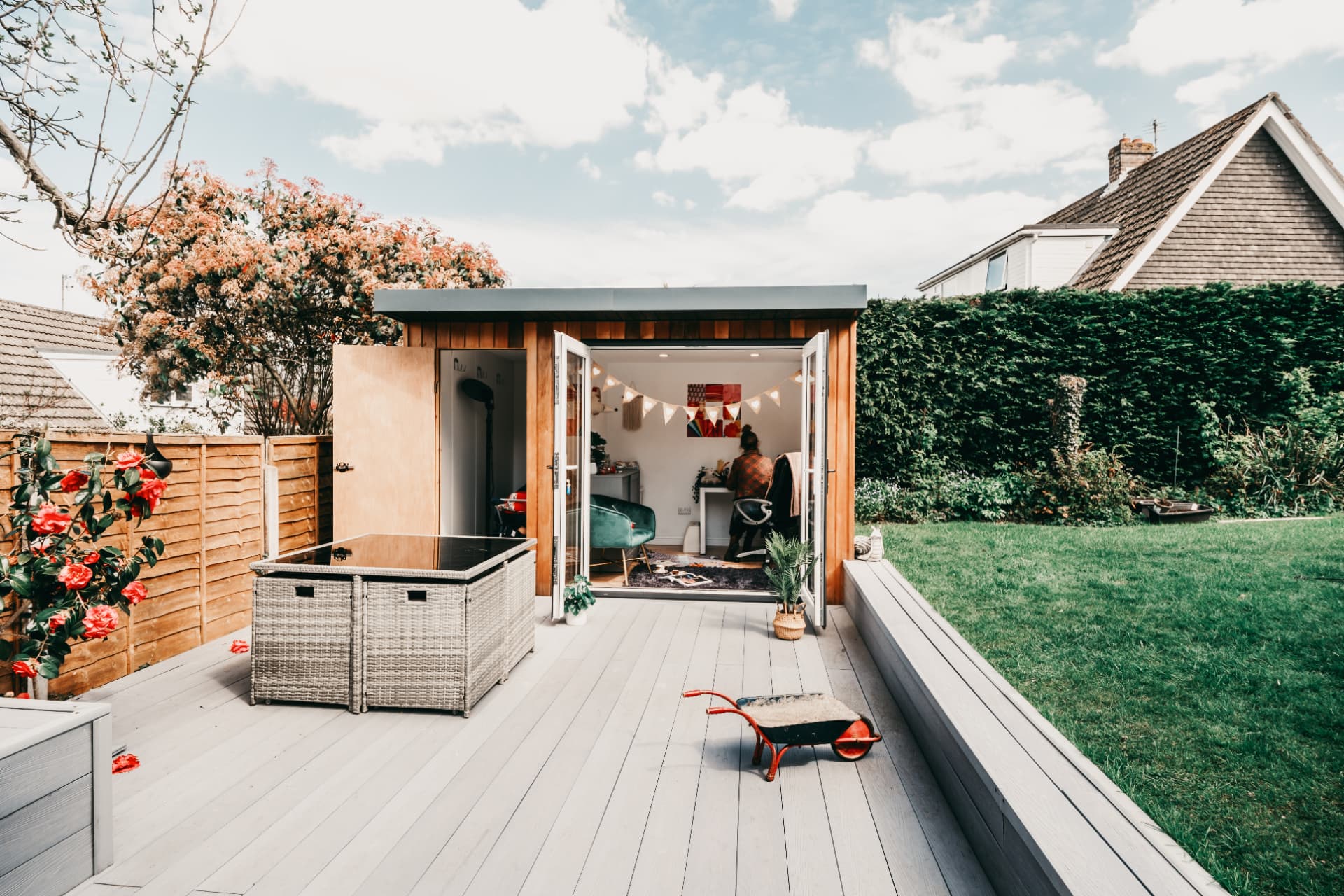 Cedar garden craft room with French doors open onto a wide composite deck