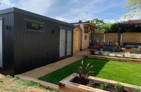 Long anthracite clad garden room with side door and French doors in a landscaped garden