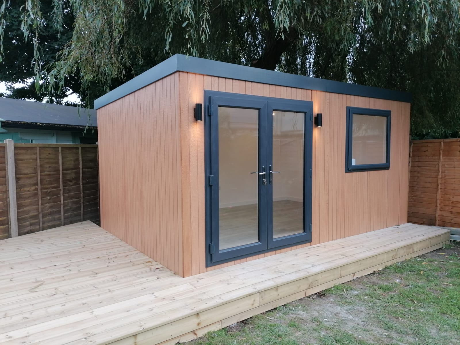 Astana Range Cedar ToughWood garden room on a new timber deck at dusk