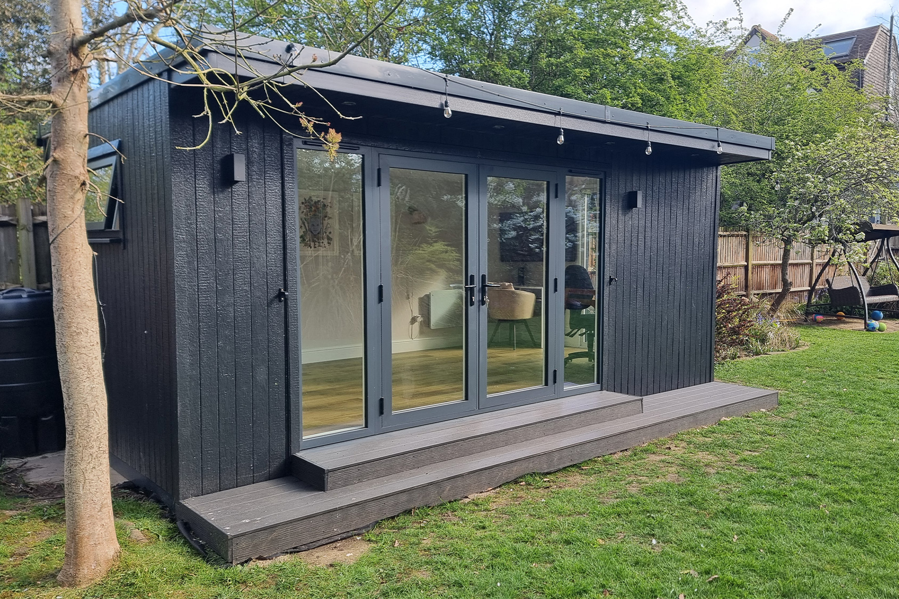 Granite ToughWood garden room with grey bifold doors and a composite deck