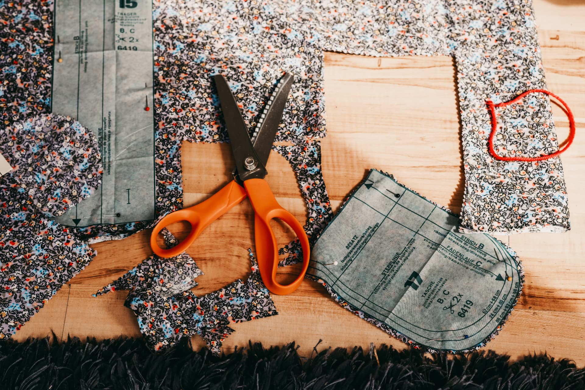 Dressmaking patterns, fabric and shears laid out on a garden room worktop