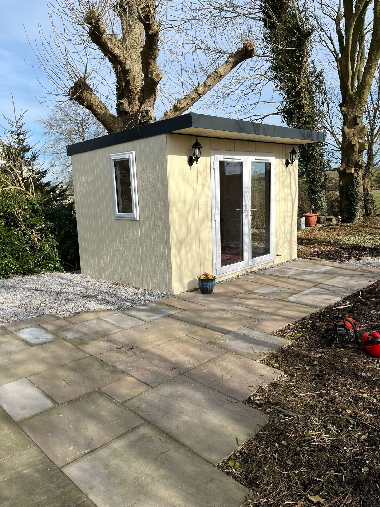 Custom cream and sage ToughWood garden room with white French doors and coach lights