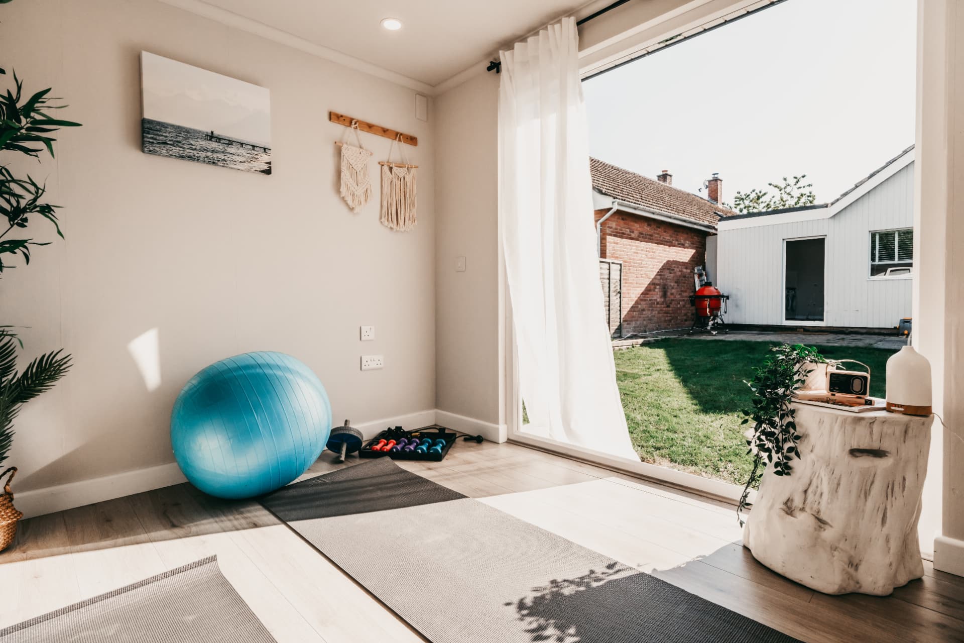 Garden yoga studio with mats, exercise ball and dumbbells beside open doors