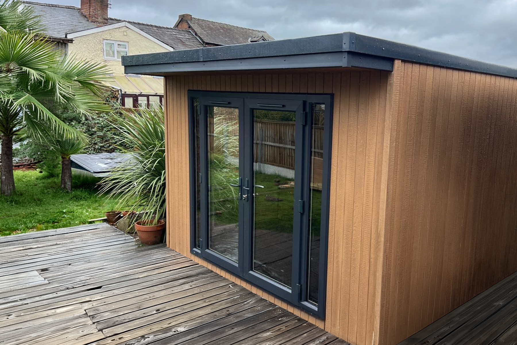 Cedar clad garden room with French doors on a raised deck