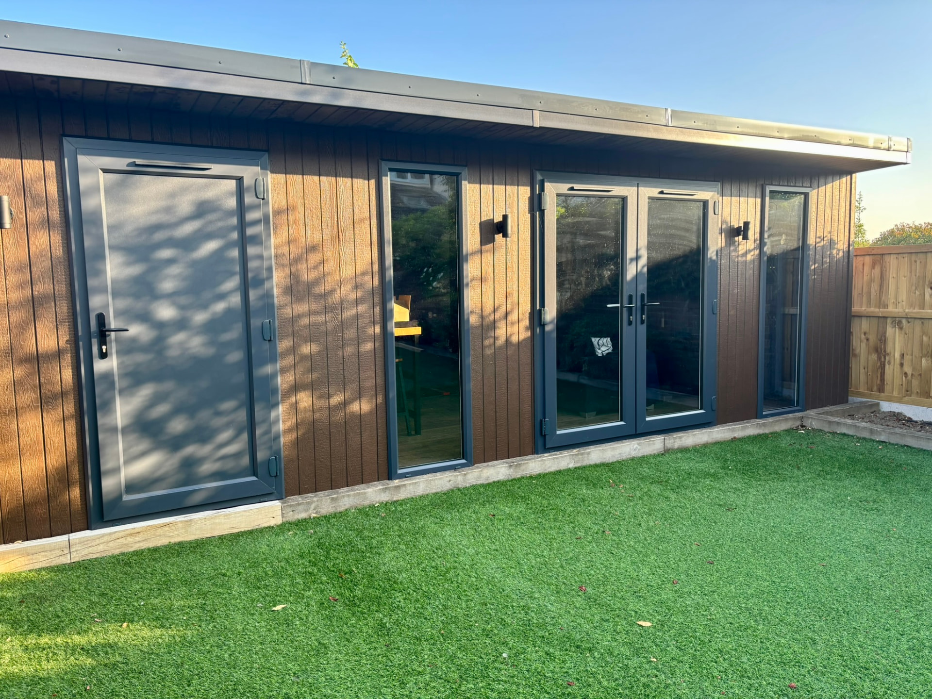 Side view of a Weathered Oak ToughWood garden room with side door and French doors