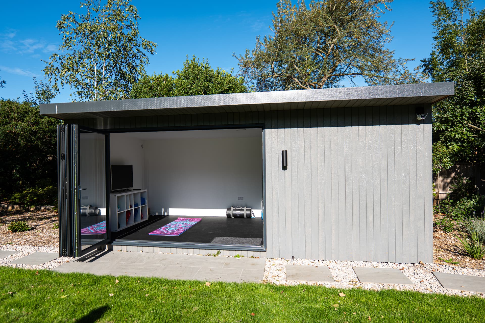 Mountain Ash garden room set up as a yoga studio with doors open to the lawn