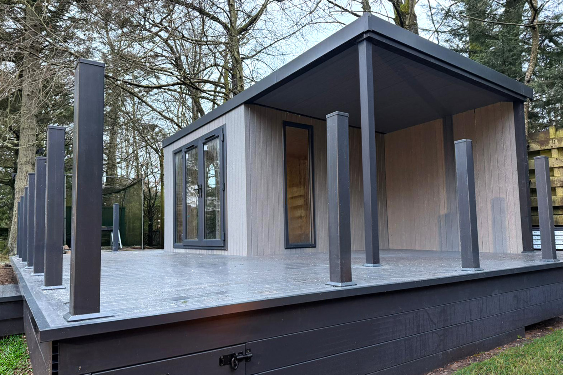 No-overhang garden room with an integrated covered veranda and composite deck